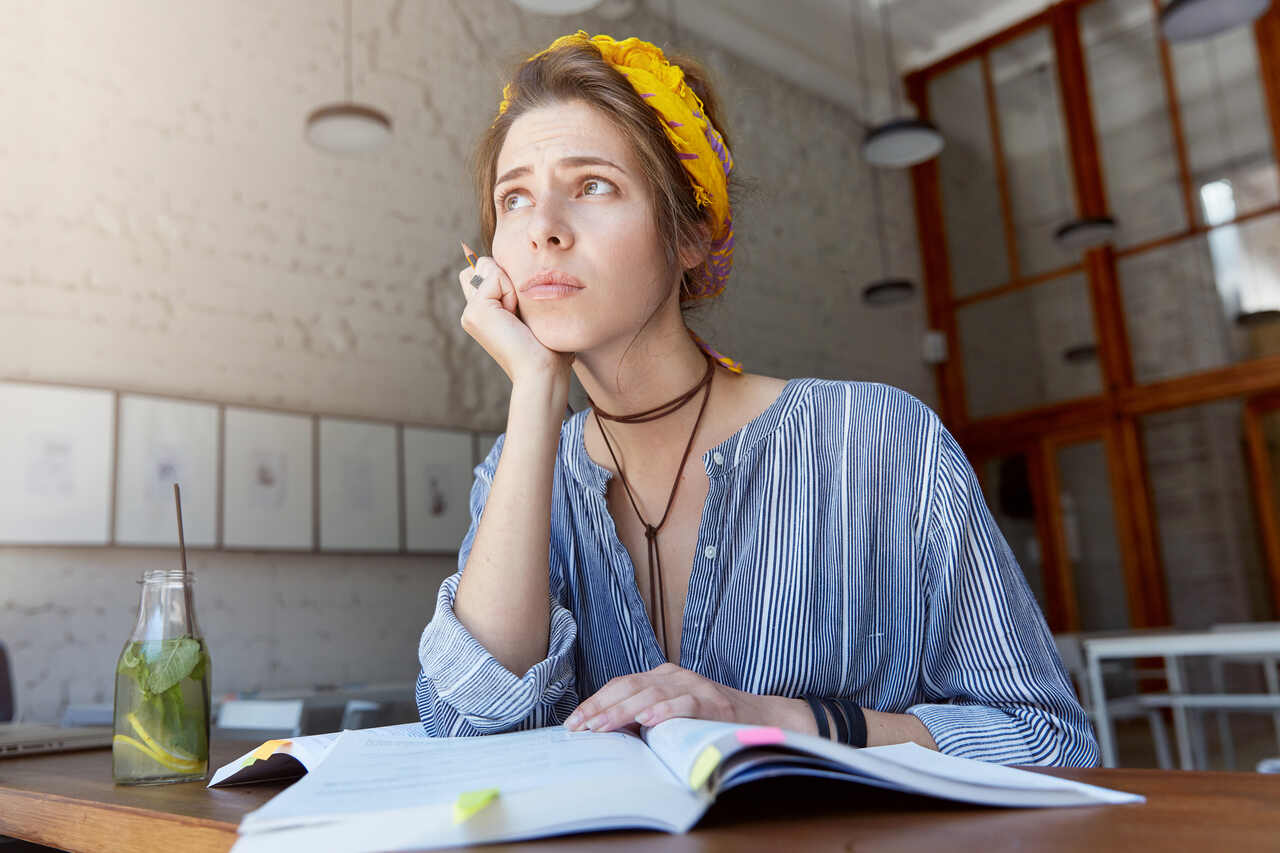 Jovem estudando com expressão pensativa 