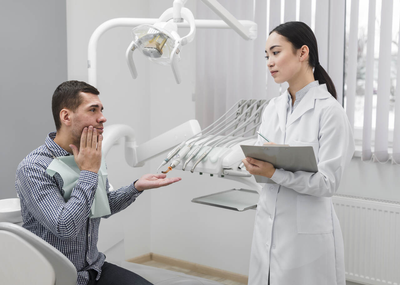 Dentista ouve queixas de paciente 