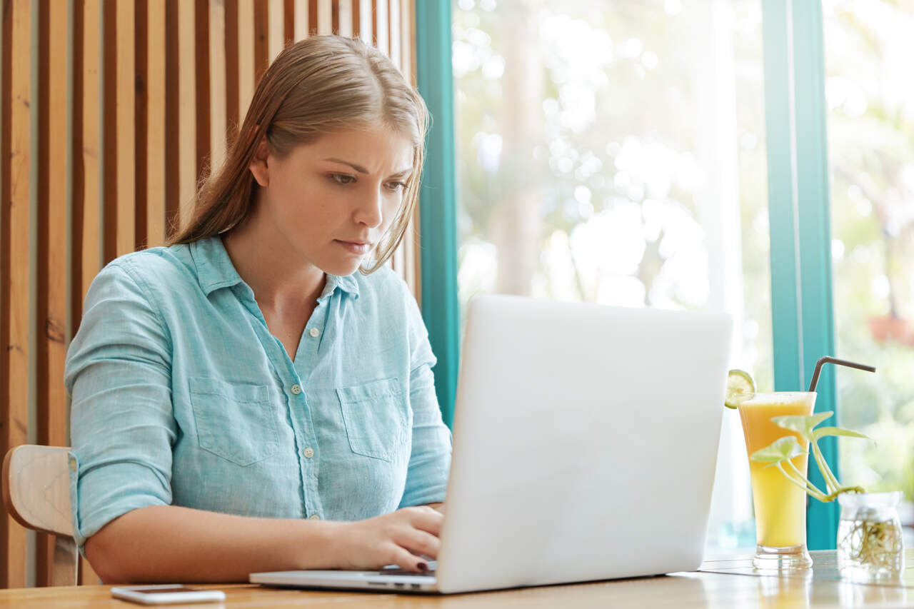 Jovem atenta ao notebook em sua frente 