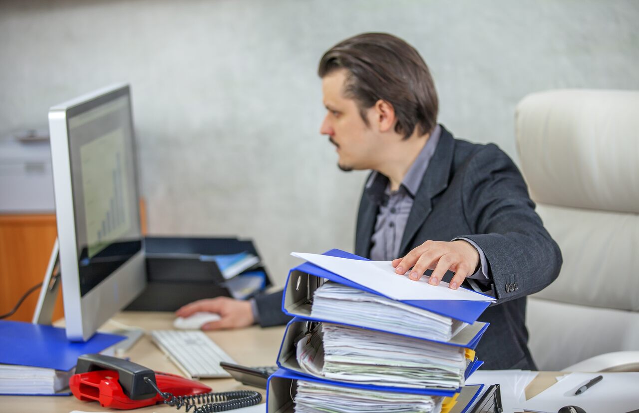 Profissional trabalha em sua mesa em setor administrativo de empresa