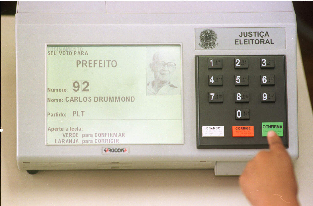 Close de pessoa votando em urna eletrônica 