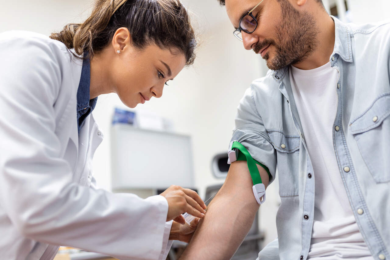 Enfermeira faz coleta de sangue de paciente 