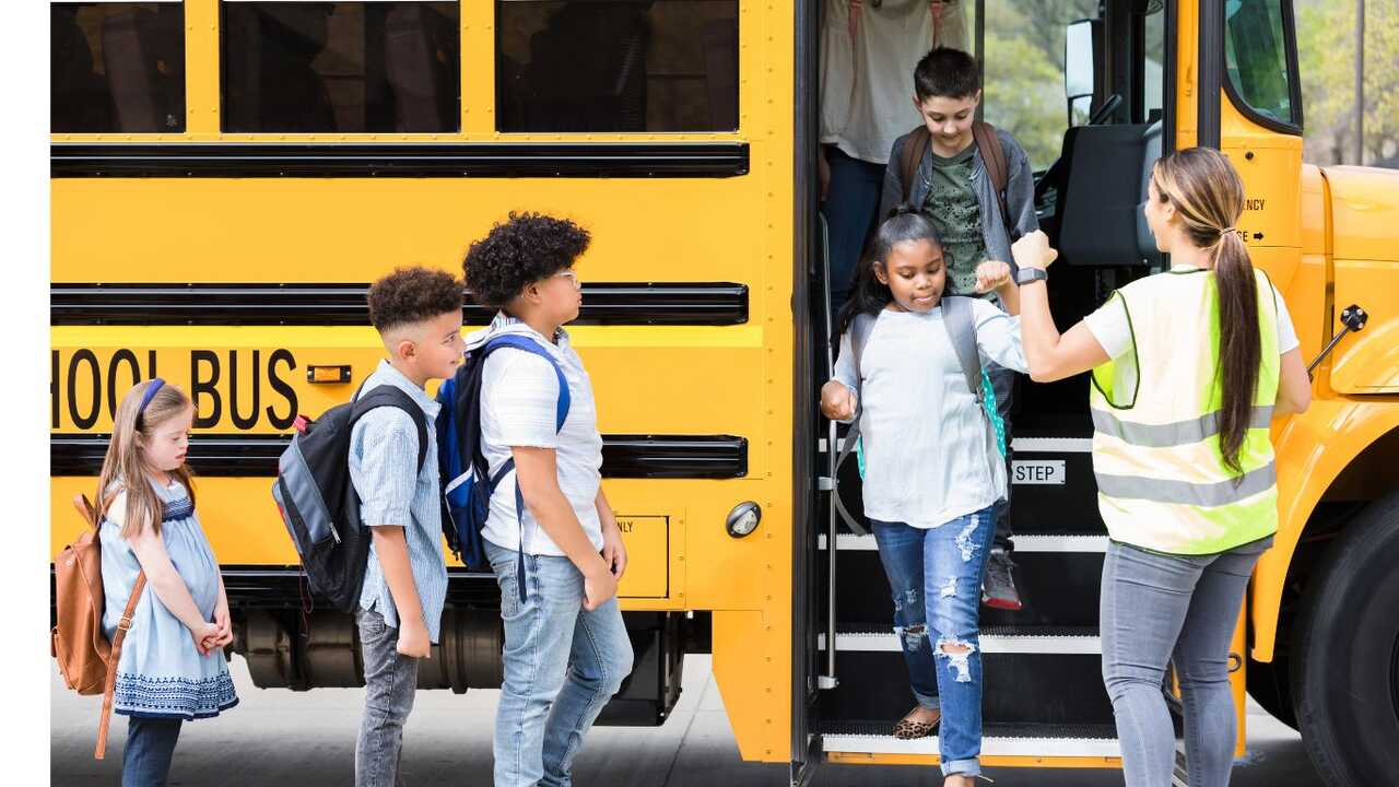 Monitor de Transporte Escolar recebe crianças no ônibus 