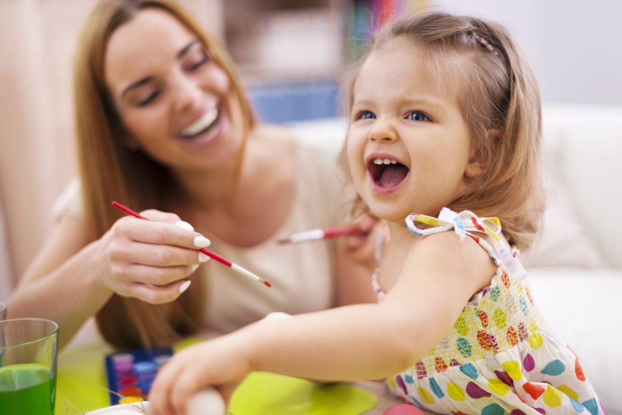 Auxiliar realiza atividade de pintura com bebê na creche 